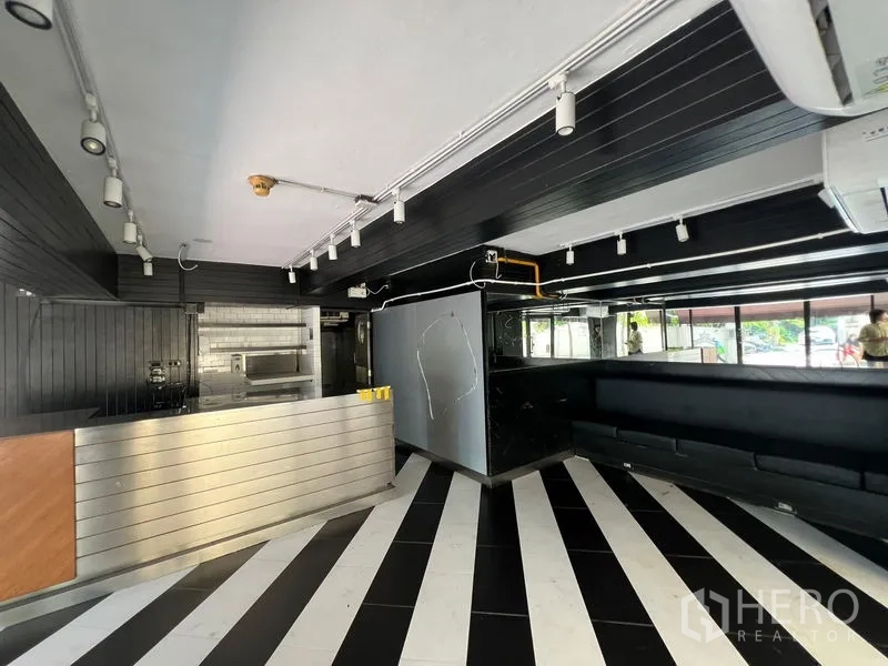 零售空间 出租在Bang Rak, Bangkok - 销售区设长条座位、外露管线和轨道灯。