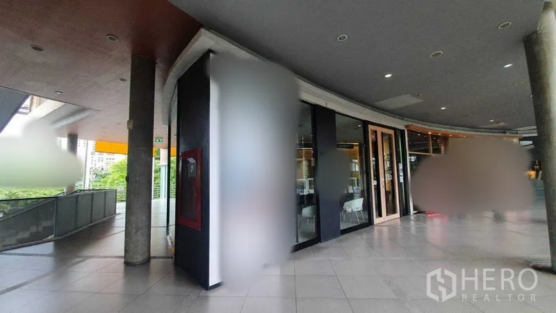 零售空间 出租在Khlong Toei, Bangkok - 沿商场弧形走道的宽阔店面与筒灯顶棚