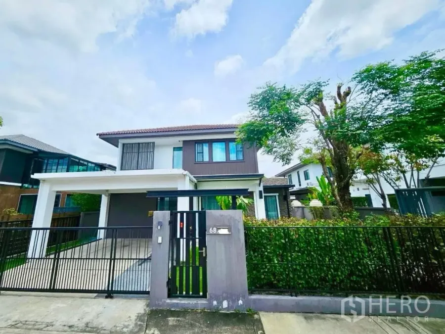 Detached House for rent or sale in Bang Phli, Samut Prakan - Front exterior of a modern two-storey detached house with gated driveway and covered carport.