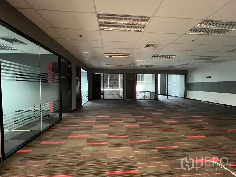 办公空间 出租在Huai Khwang, Bangkok - 大型开放工位区，条纹地毯，四周为玻璃隔间。