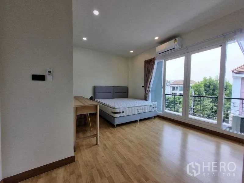 ทาวน์เฮาส์ ให้เช่าในWang Thonglang, Bangkok - ห้องนอนมุมมีโต๊ะทำงาน แอร์ และประตูกระจกบานกว้างสู่ระเบียง