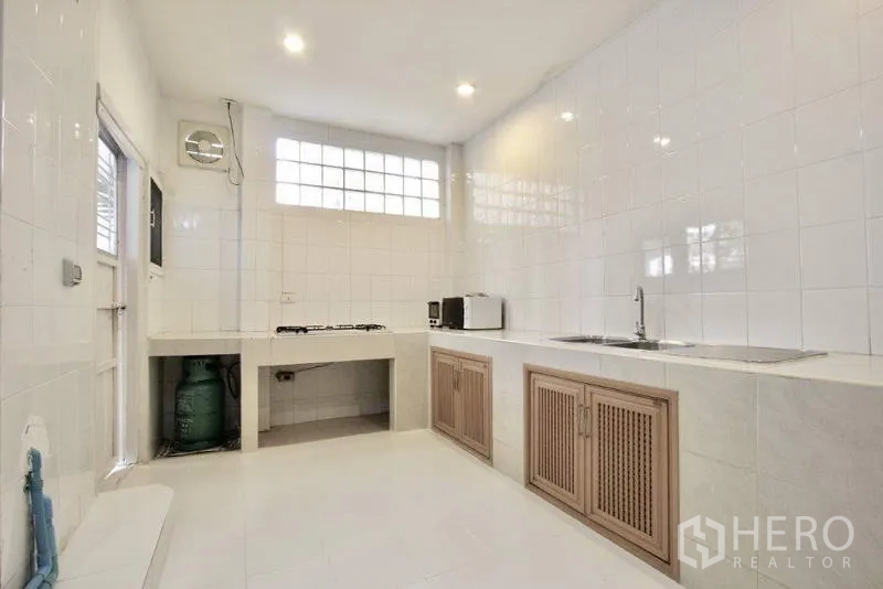 ทาวน์เฮาส์ ขายในSuan Luang, Bangkok - ครัวไทยปูกระเบื้องสีขาว เคาน์เตอร์ซิงก์ เตาแก๊ส และตู้เก็บของ