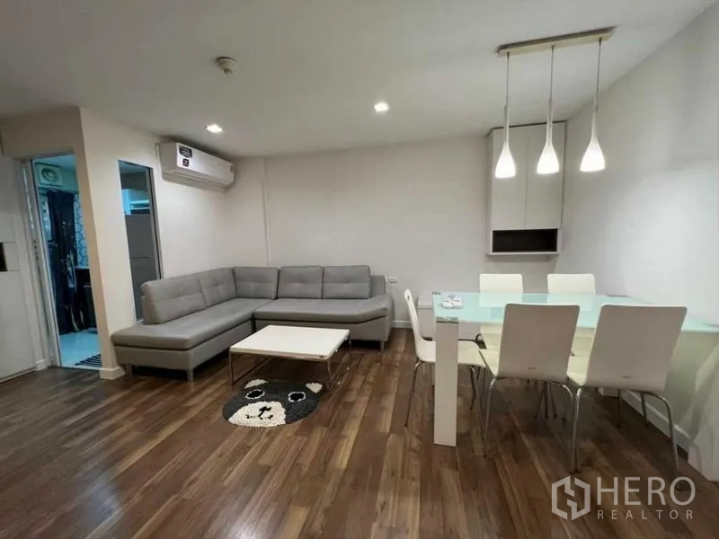 คอนโด ขายในWatthana, Bangkok - พื้นที่นั่งเล่นและรับประทานอาหารแบบเปิดโล่ง โซฟา L โต๊ะกินข้าวกระจก และโคมแขวน