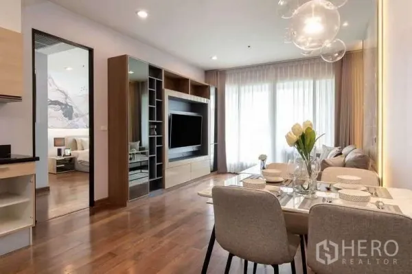 คอนโด ให้เช่าในPathum Wan, Bangkok - พื้นที่นั่งเล่นและรับประทานอาหารแบบเปิดโล่ง พื้นไม้ ตู้ทีวีบิลท์อิน และม่านสูงจรดเพดาน