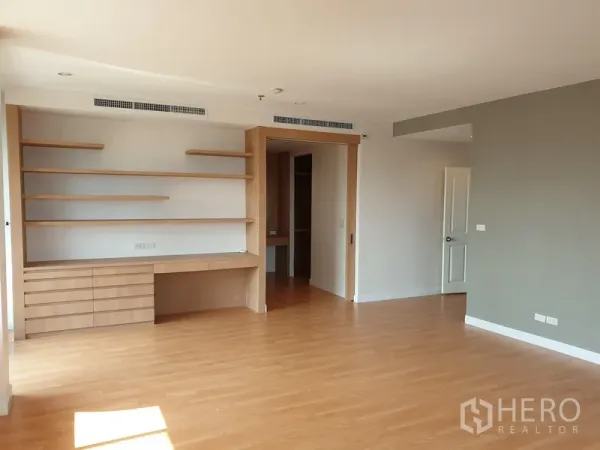 公寓 出租在Watthana, Bangkok - 宽阔多功能房，悬浮置物架与书桌，木地板并通向更衣区。