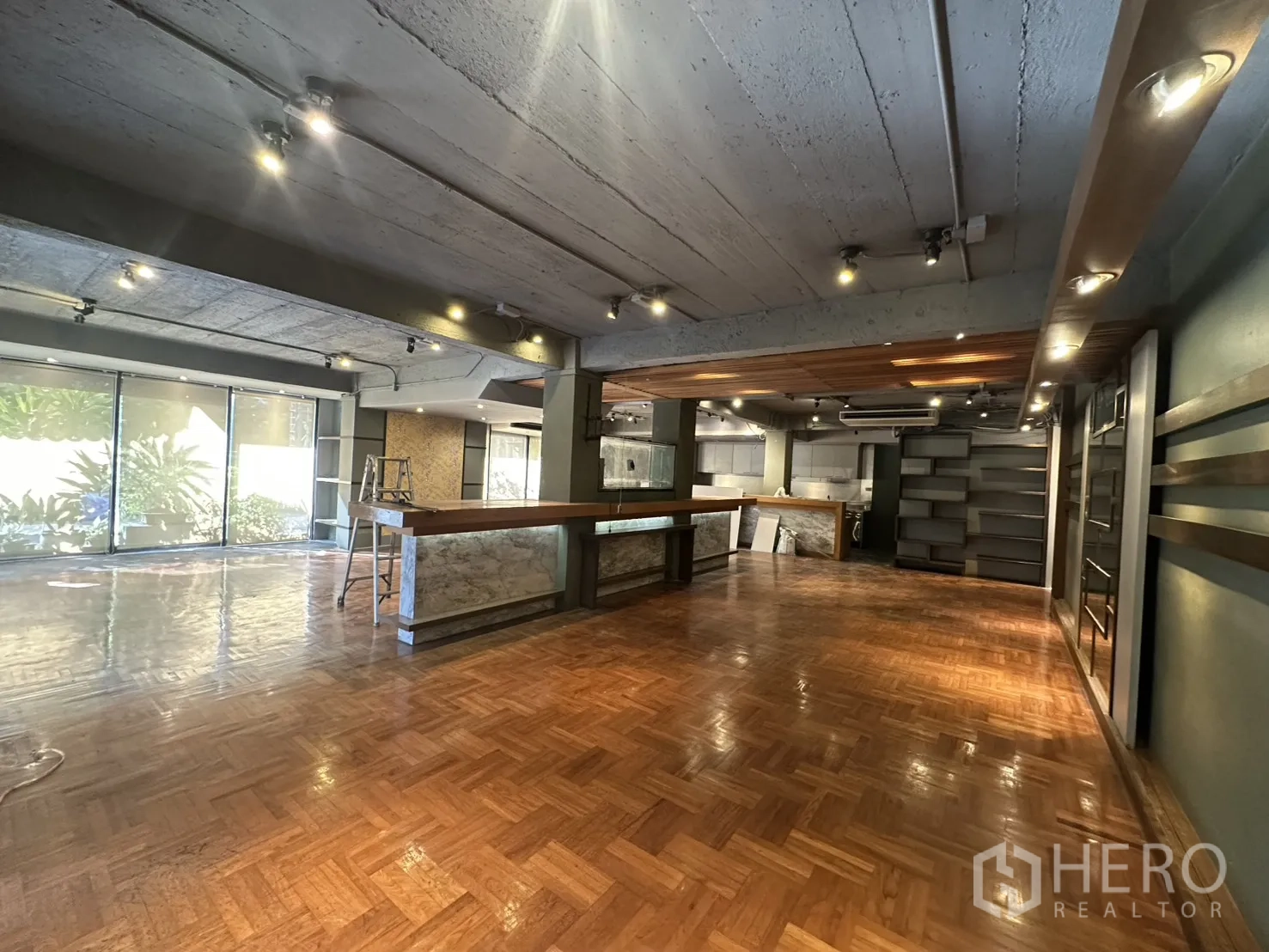 Retail Space for rent in Watthana, Bangkok - Open‑plan retail interior with parquet floors, long service counter, shelving, and track lighting.