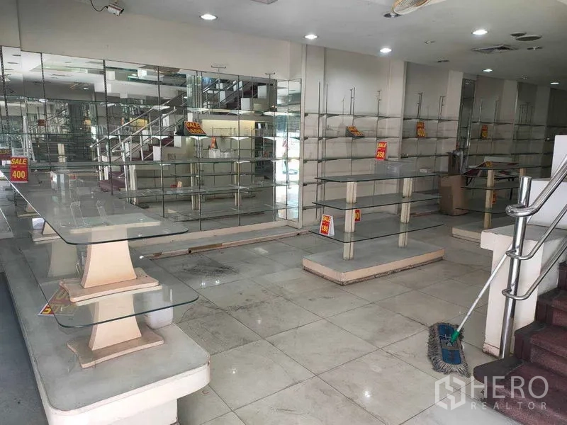 อาคารพาณิชย์ ให้เช่าในWatthana, Bangkok - พื้นที่ค้าขายชั้นล่างพร้อมชั้นวางกระจก ผนังกระจกเงา พื้นกระเบื้อง และบันได