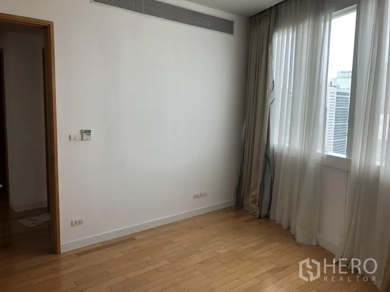 คอนโด ให้เช่าในKhlong Toei, Bangkok - ห้องนอนมีหน้าต่างชมวิวเมือง ผ้าม่านโปร่ง พื้นไม้โทนอ่อน