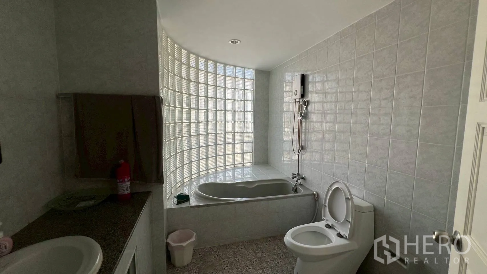 家庭办公室 for rent in Wang Thonglang, Bangkok - 浴室配浴缸、淋浴、坐便与弧形玻璃砖墙。