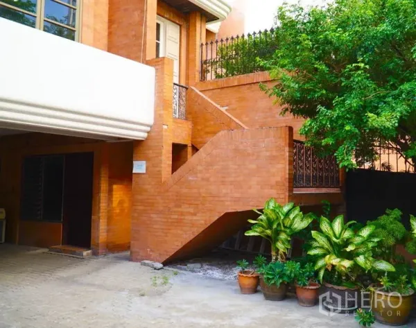 Townhouse for rent in Pathum Wan, Bangkok - Exterior brick staircase with potted plants and a side entrance.
