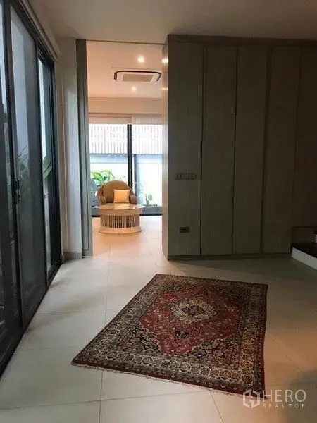 Townhouse for rent in Khlong Toei, Bangkok - Entrance hall with sliding glass doors, recessed lighting and a patterned rug.