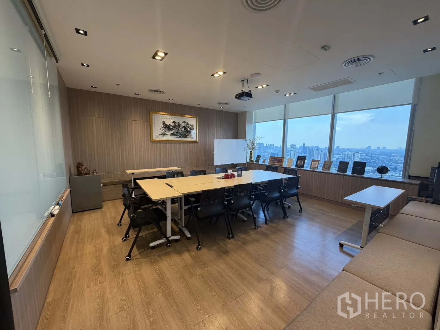Office Space for rent in Khlong Toei, Bangkok - Large meeting room with conference tables, chairs, projector, whiteboard, and wide windows showing a city skyline.