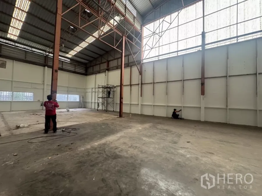 工厂 出租在Pak Kret, Nonthaburi - 高位厂房，钢柱林立，半透明墙板使空间明亮通透。