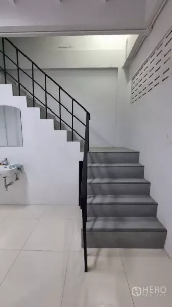 ทาวน์เฮาส์ ให้เช่าในHuai Khwang, Bangkok - บันไดสีเทาพร้อมราวเหล็กดำและอ่างล้างมือใต้บันได