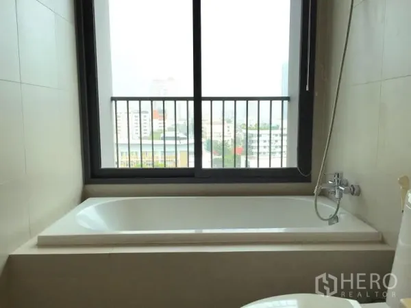 คอนโด ให้เช่าหรือขายในKhlong Toei, Bangkok - ห้องน้ำมีอ่างอาบน้ำใต้หน้าต่างบานใหญ่ มองเห็นวิวเมืองในคอนโดกรุงเทพ