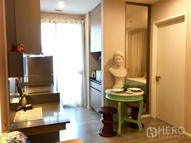 公寓 出租或出售在Watthana, Bangkok - 紧凑一体式厨房，内置橱柜，窗边小餐桌。