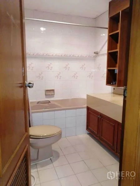 Condominium for rent in Watthana, Bangkok - Bathroom with bathtub, vanity and white ceramic tiles.