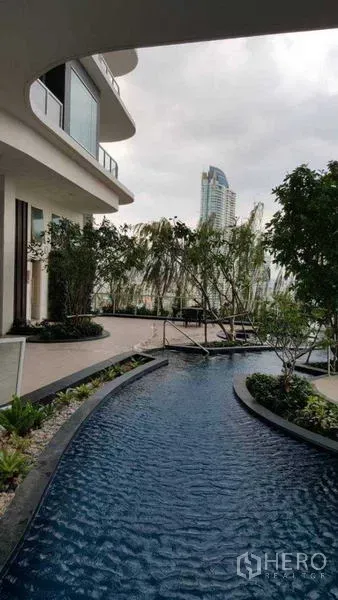 Condominium for rent in Bang Kho Laem, Bangkok - Curved water feature and landscaped garden beside a modern condominium.