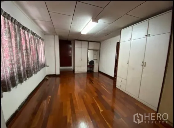 Home Office for rent in Suan Luang, Bangkok - Spacious bedroom or office with polished wood floors, built-in wardrobes and a fluorescent ceiling light.