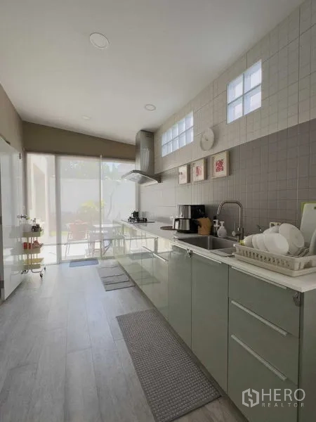 บ้าน ให้เช่าหรือขายในBang Khen, Bangkok - ครัวรูปแบบแกลลีย์ ตู้บิวท์อิน เครื่องดูดควัน และประตูกระจกออกสู่ลาน