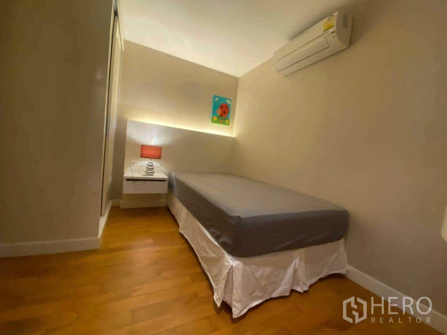 公寓 出租在Watthana, Bangkok - 第三卧室配单人床、空调与木地板，空间紧凑。