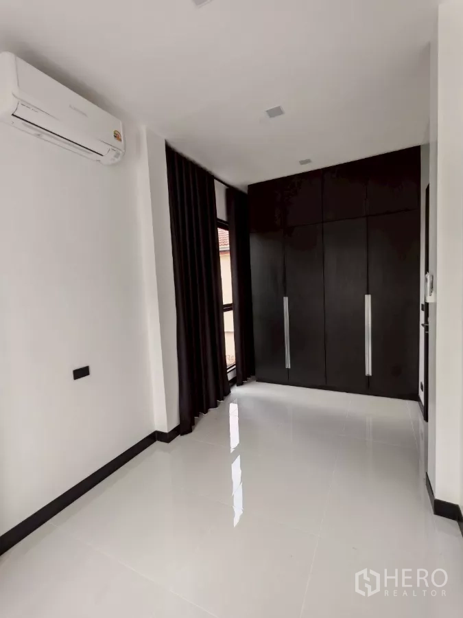 บ้าน ให้เช่าในWang Thonglang, Bangkok - ห้องสว่างมีเครื่องปรับอากาศและตู้เสื้อผ้าบิวท์อินสีดำข้างหน้าต่าง