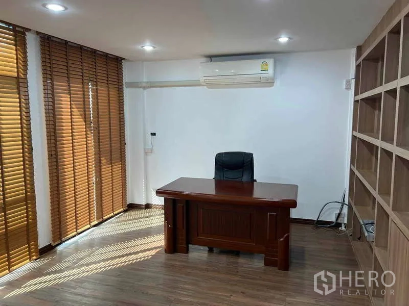 Home Office for rent in Bueng Kum, Bangkok - Bright executive office with large blinds, built-in shelving and wooden desk under wall AC.