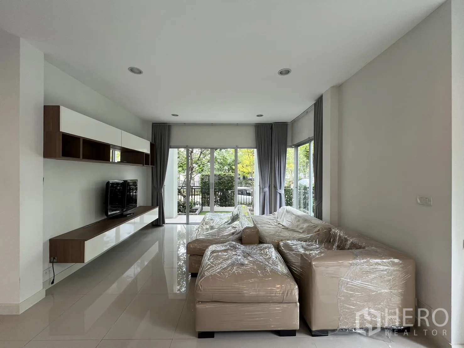 独立式住宅 出租在Saphan Sung, Bangkok - 修长客厅，落地窗与窗帘一应俱全