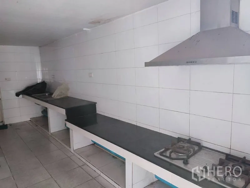 Office Space for rent in Saphan Sung, Bangkok - Long galley pantry with tiled walls, range hood and gas cooktop