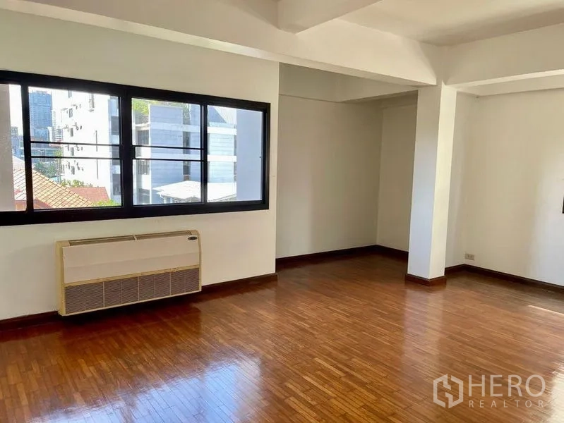 Home Office for rent - Spacious room with polished wood flooring, wide windows and a wall-mounted air conditioner.