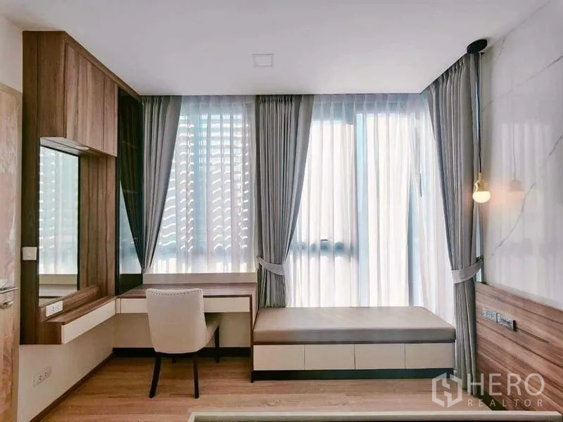 公寓 出租在Ratchathewi, Bangkok - 明亮角落，带内置书桌与梳妆台，旁有大窗帘。