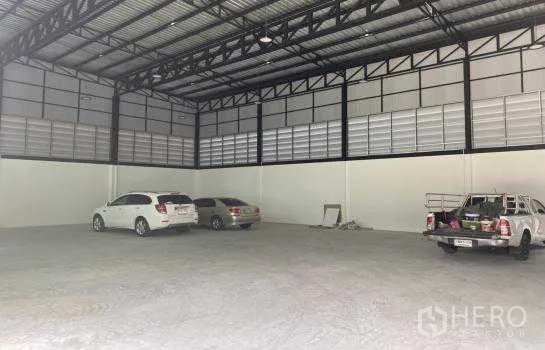 货栈 出租在Prawet, Bangkok - 高挑钢结构仓库内部，混凝土地面开阔，可停放多辆车并用于储存。