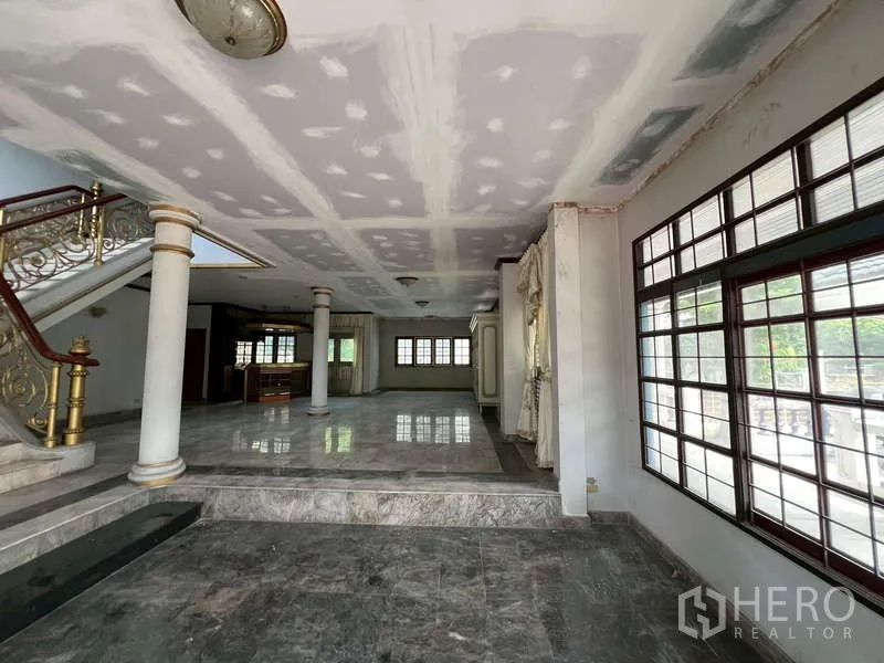 Detached House for rent in Prawet, Bangkok - Spacious living area with marble flooring, pillars and large windows.