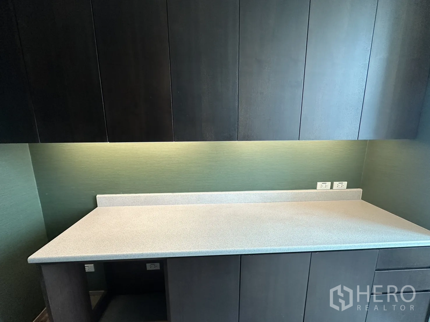 ออฟฟิศ for rent in Watthana, Bangkok - ภาพใกล้เคาน์เตอร์ท็อปพร้อมแผงกันเปื้อน ปลั๊กไฟ และตู้แขวน