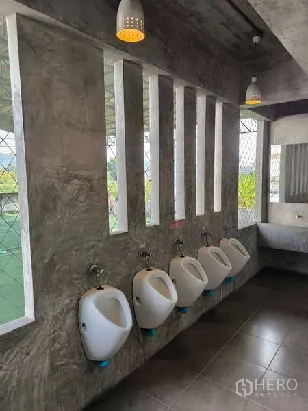 Warehouse for rent in Huai Khwang, Bangkok - Bright restroom corridor featuring five urinals and vertical slit windows.