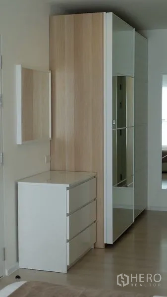 公寓 出售在Khlong Toei, Bangkok - 卧室内带镜面推拉门的内置衣柜与白色抽屉柜。