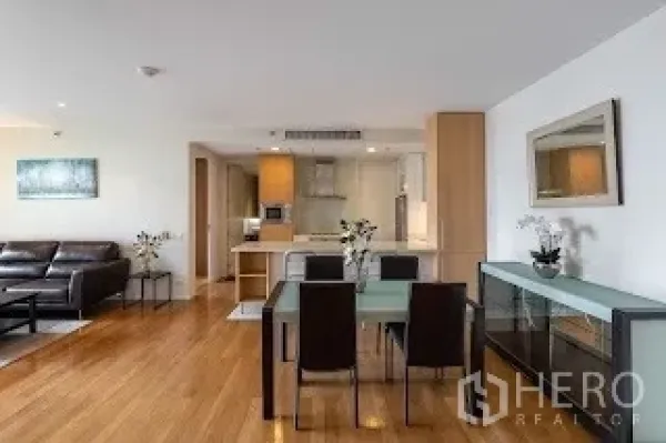 Condominium for rent in Bang Rak, Bangkok - Dining space next to a modern kitchen with glass-front cabinets and built-ins.