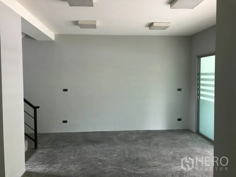 Home Office for rent in Wang Thonglang, Bangkok - Open room with sliding glass door to a balcony and stair rail nearby.