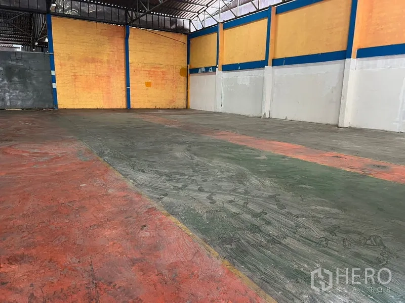 คลังสินค้า ให้เช่าในMueang Samut Prakan, Samut Prakan - ลานเก็บสินค้าพื้นคอนกรีต ผนังสีเหลือง คานเหล็กสีน้ำเงิน และความสูงโปร่ง