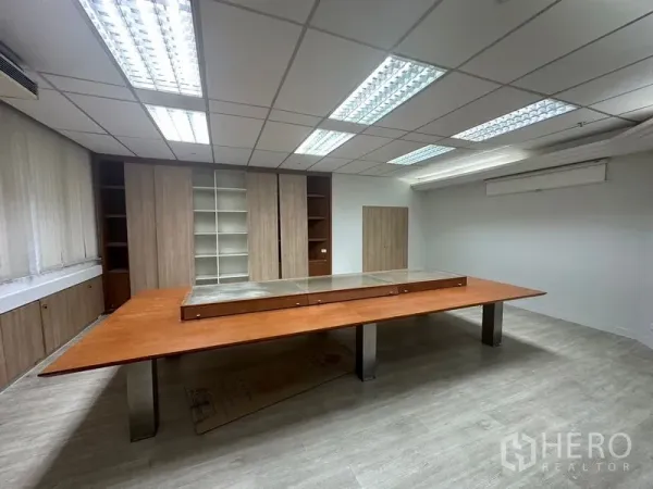 办公空间 出租在Din Daeng, Bangkok - 会议室内长木质桌、内置柜与格栅吊顶灯，Din Daeng 办公室。