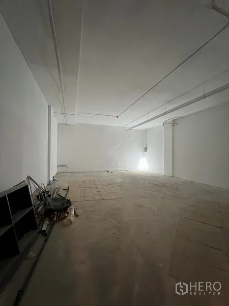 พื้นที่ขายปลีก ให้เช่า - ห้องทรงสี่เหลี่ยมยาว เพดานสูง พื้นยังไม่ปู และจุดต่อสาธารณูปโภคริมผนัง