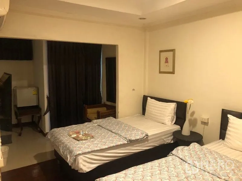 พื้นที่ขายปลีก ให้เช่าในKhlong Toei, Bangkok - ห้องแขกเตียงเดี่ยวสองเตียง พร้อมโต๊ะข้างและผ้าม่านสีเข้ม