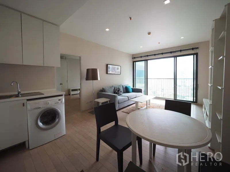 公寓 出租在Watthana, Bangkok - 餐区毗邻厨房，连接采光良好的客厅与阳台。