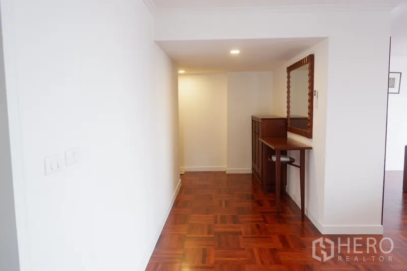 公寓 出租在Khlong Toei, Bangkok - 走廊木地板，设有控制台与大镜子，筒灯照明