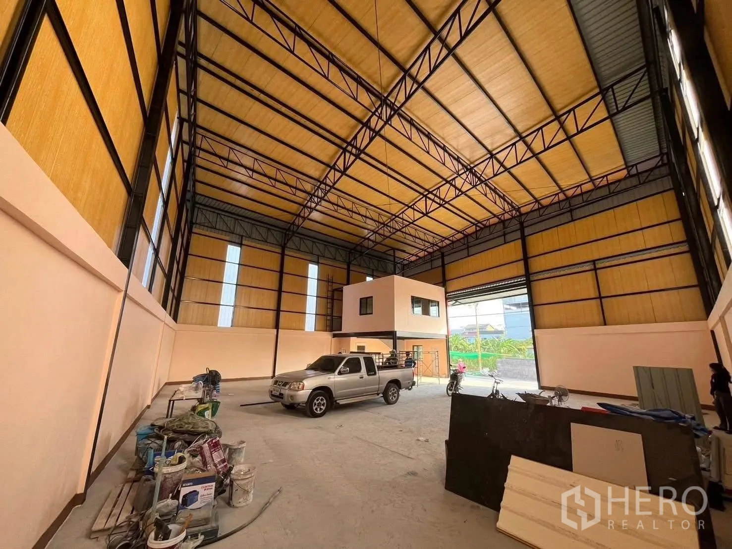 Warehouse for rent in Bang Phli, Samut Prakan - Open-plan warehouse interior with high roof, concrete floor, mezzanine office and large roller shutter.