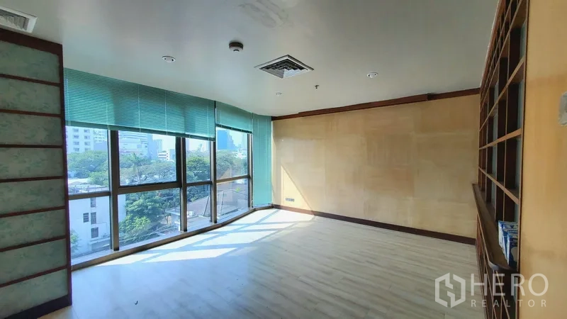 สำนักงาน ให้เช่าในKhlong Toei, Bangkok - ห้องทำงานมุมอาคารสว่าง หน้าต่างกระจกเต็มบานพร้อมมู่ลี่ พื้นไม้โทนอุ่น เห็นวิวเมือง ย่านพร้อมพงษ์