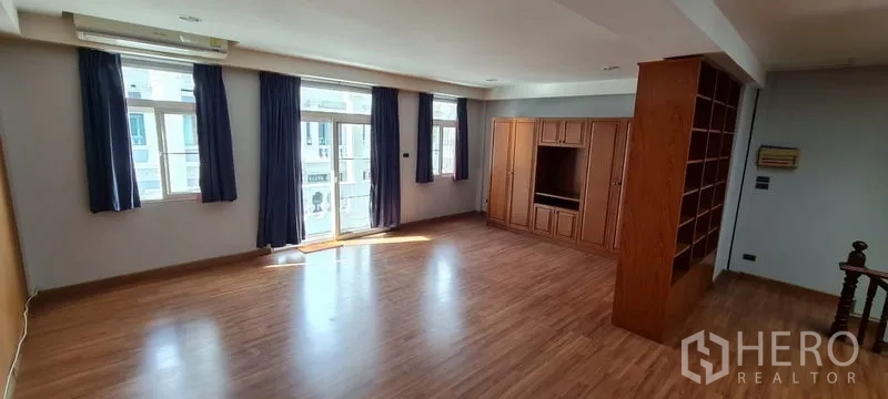 Townhouse for rent in Watthana, Bangkok - Sunlit top-floor multipurpose room with built-in cabinets and balcony doors.