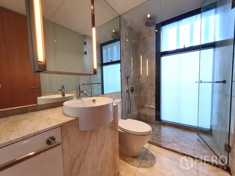 Condominium for rent in Sathon, Bangkok - Second bathroom with frameless glass shower, rain head and marble vanity.