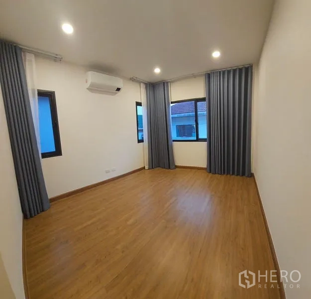 บ้าน ให้เช่าในSaphan Sung, Bangkok - ห้องนอนกว้าง พื้นไม้ หน้าต่างหลายบาน ผ้าม่าน และเครื่องปรับอากาศ.