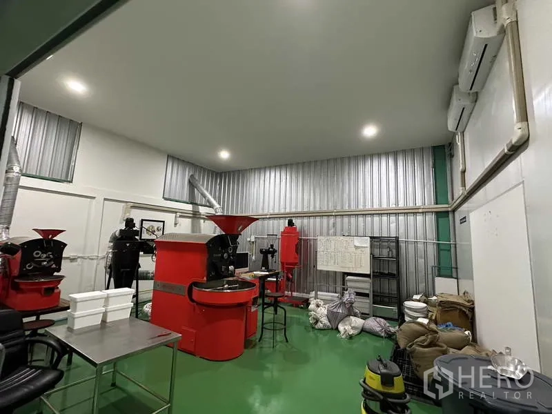 Factory for rent in Khlong Luang, Pathum Thani - Production room featuring red industrial roasting machines and high ceiling with air-conditioning.